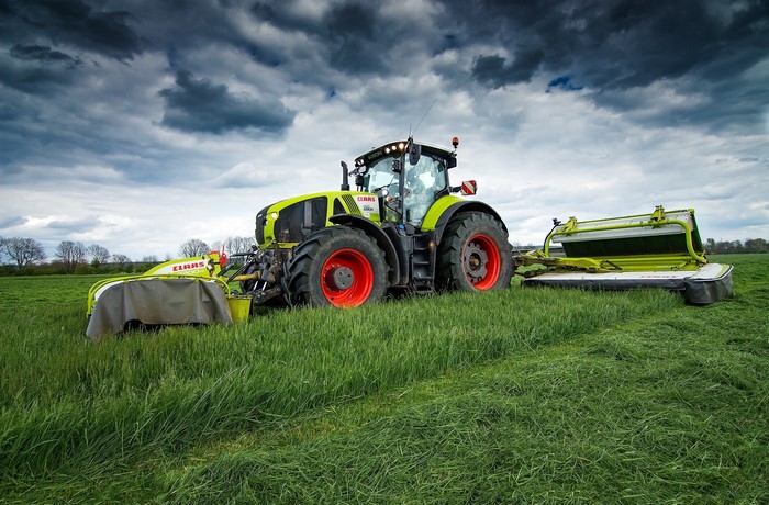 Claas Axion 950 tractor with mowers in a field