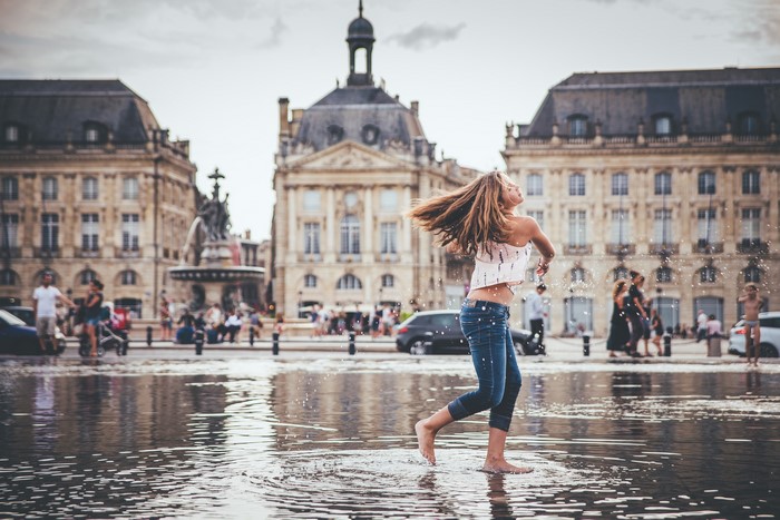 Girl playing in water at Place de la Bourse, Bordeaux