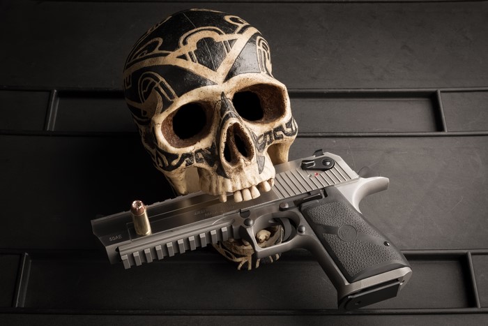 Skull with a pistol and bullet