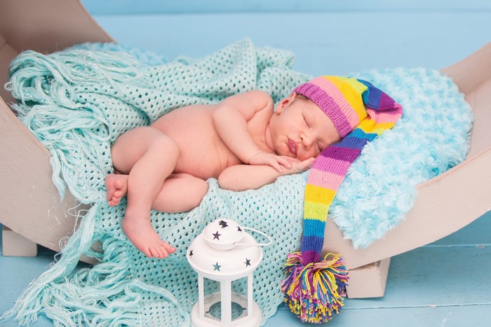 Newborn baby sleeping in a colorful winter hat