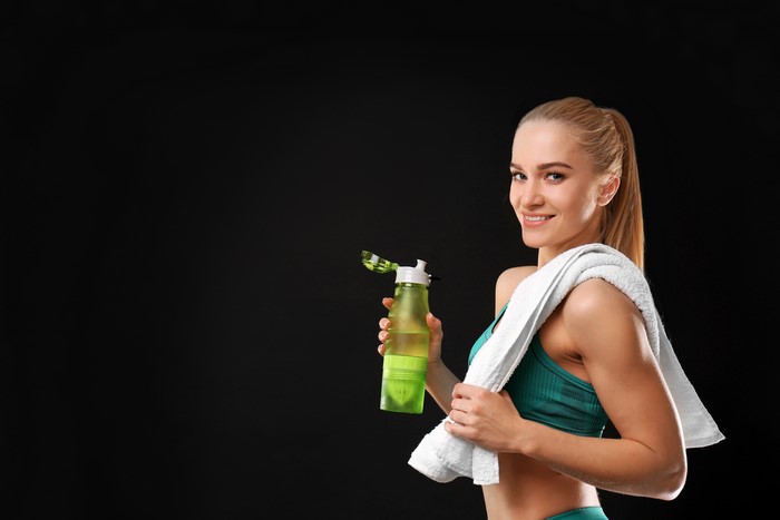 Woman with water bottle and towel