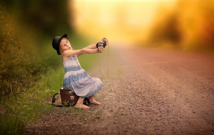 Girl in hat taking a selfie with a camera