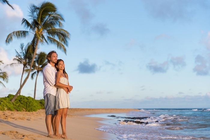 Couple hugging on a tropical beach at sunset