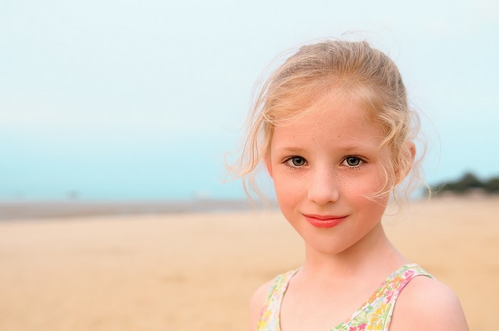 Beautiful Little Girl with Dark Blonde Hair on Beach