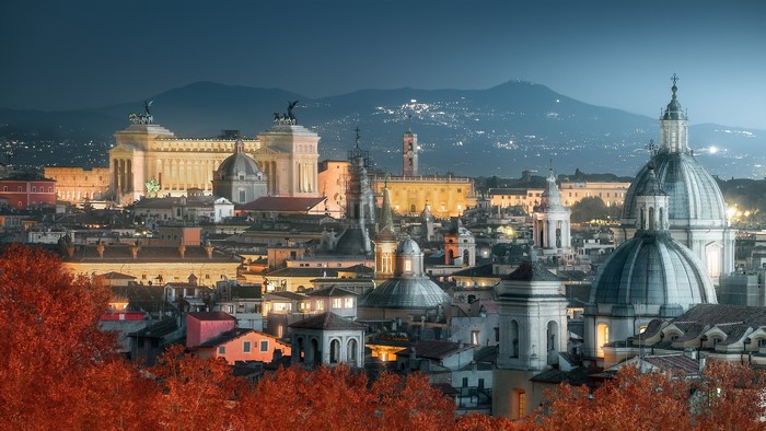 Rome cityscape at night with domes and mountains