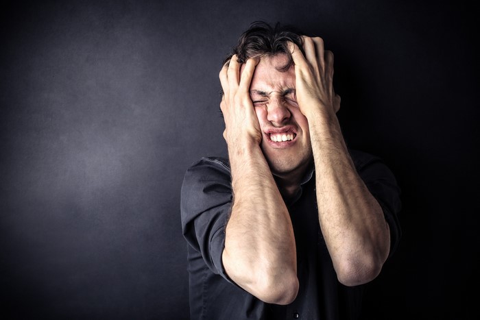 Man with hands on head in frustration