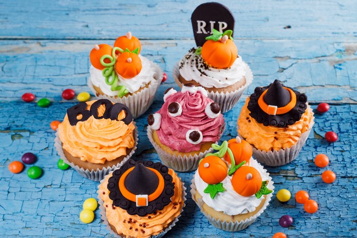Halloween cupcakes with candy on a blue wooden table
