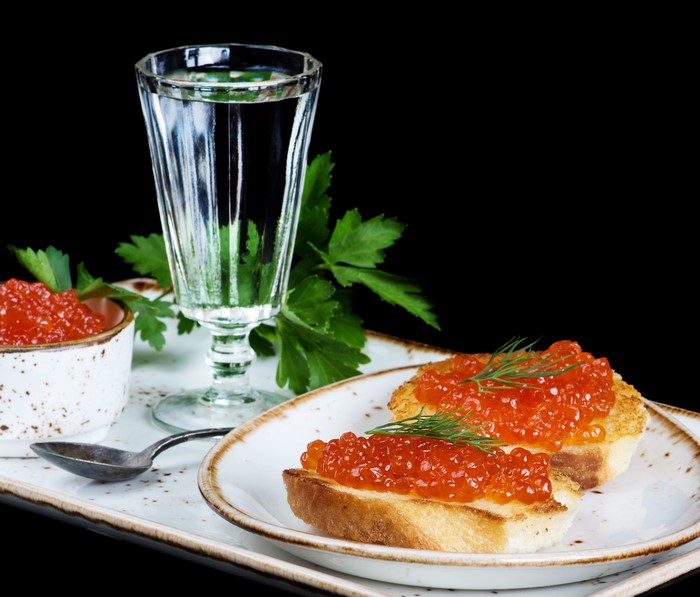 Vodka and red caviar on toast with parsley
