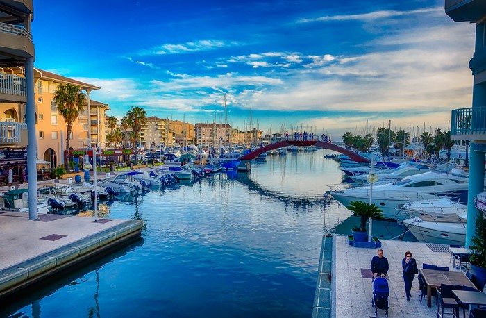 Boats docked in a canal with a bridge in France