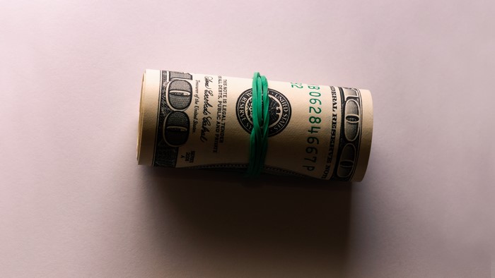 Rolled up 100 dollar bills with rubber band