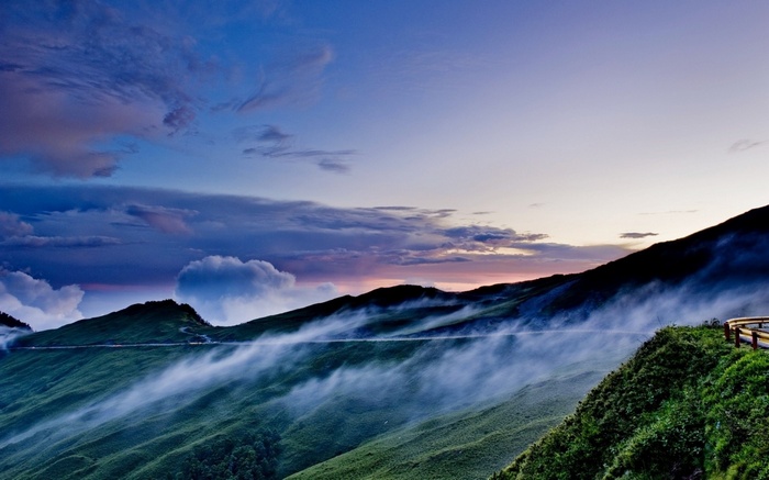Misty mountains at twilight with a winding road