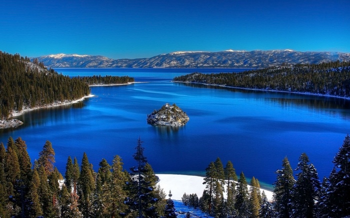 Lake Tahoe with snow-covered mountains and trees