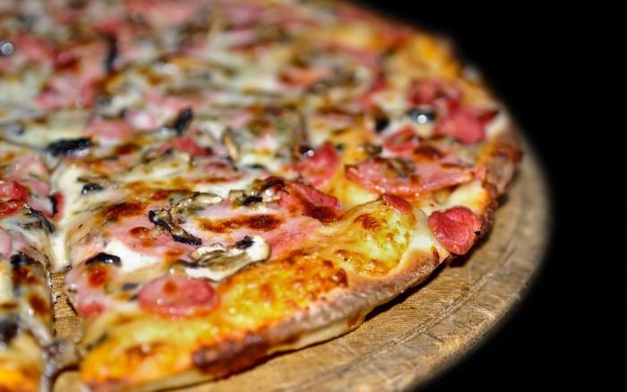 Close-up of a delicious pizza with ham and mushrooms