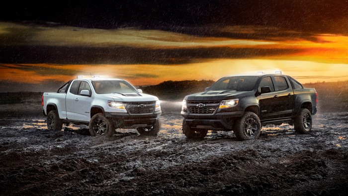 Two Chevrolet Colorado ZR2 pickup trucks in mud during rain