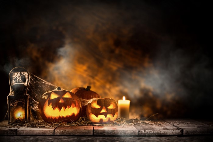 Halloween pumpkins and candle on wooden table