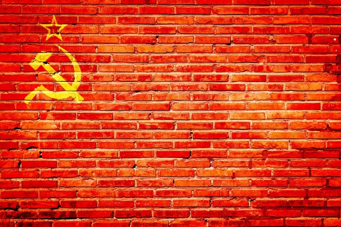Red brick wall with USSR hammer and sickle symbol