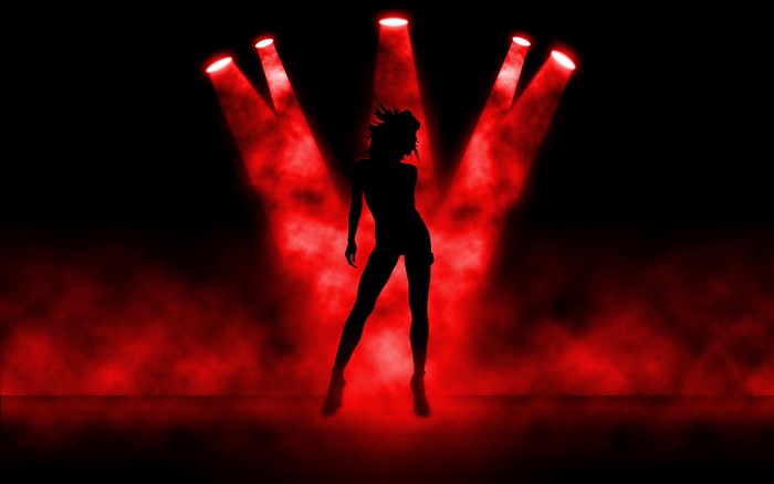 Silhouette of a dancer under red spotlights