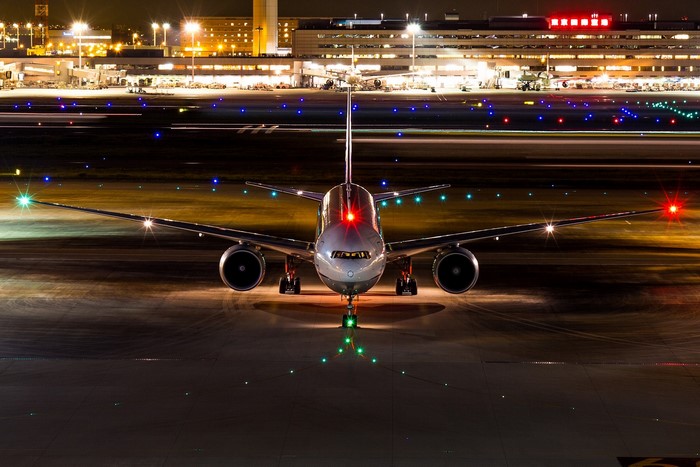 Boeing 777-300ER airplane on airport runway at night