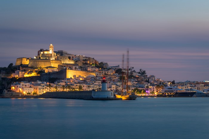 Dalt Vila Ibiza at dusk with lighthouse and yachts
