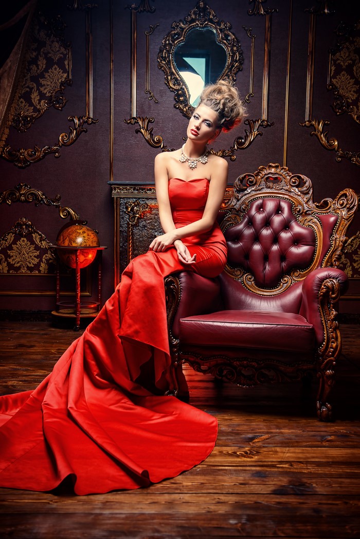Woman in red dress sitting on armchair