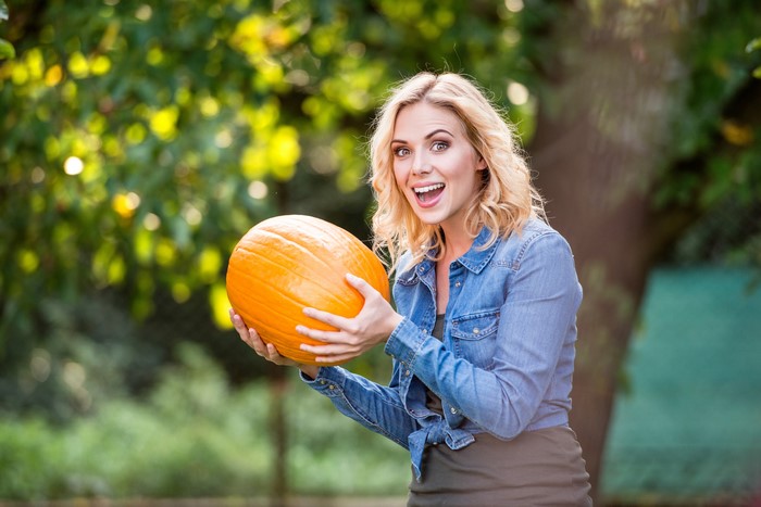 Blonde woman holding a pumpkin