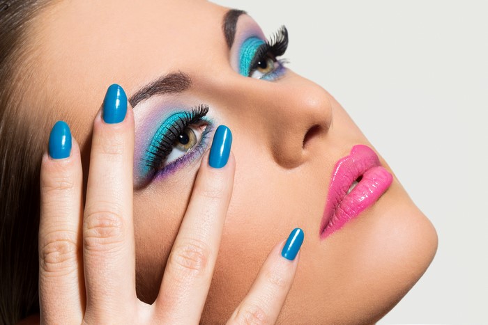 Woman with Blue Manicure and Colorful Eye Makeup