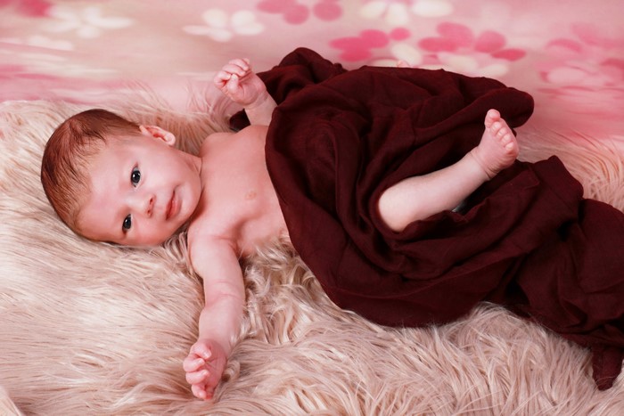 Infant lying on a fluffy rug