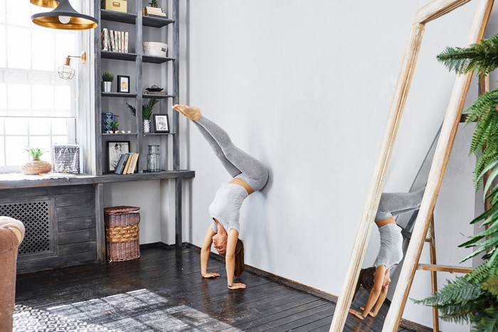 Woman doing a handstand against a wall