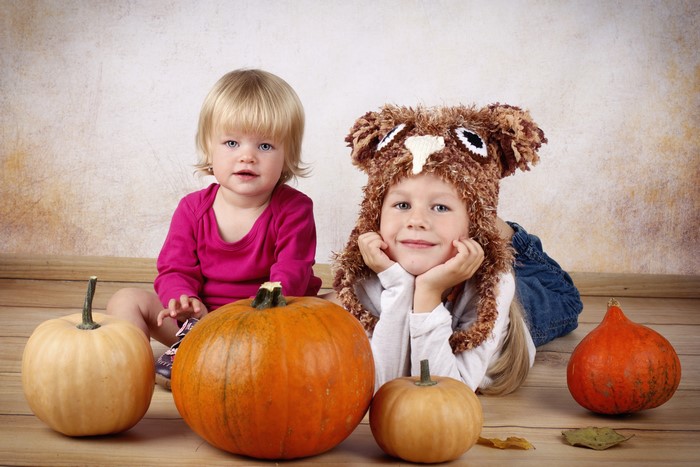 Two little girls with pumpkins