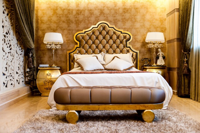 Luxurious bedroom with tufted headboard and golden accents