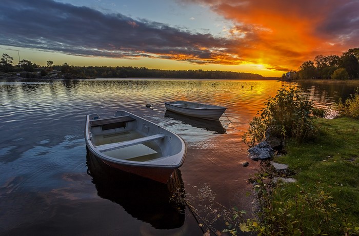 Boats on a lake at sunset with colorful sky