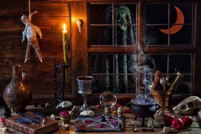 Witchcraft scene with cauldron, book, and doll