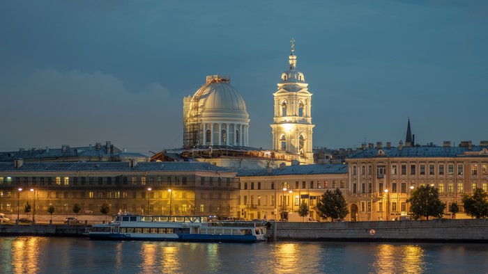 St. Petersburg riverfront with churches and riverboat at dusk