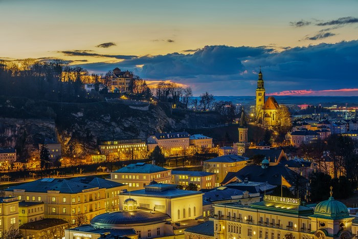Salzburg, Austria at dusk with illuminated buildings and a church