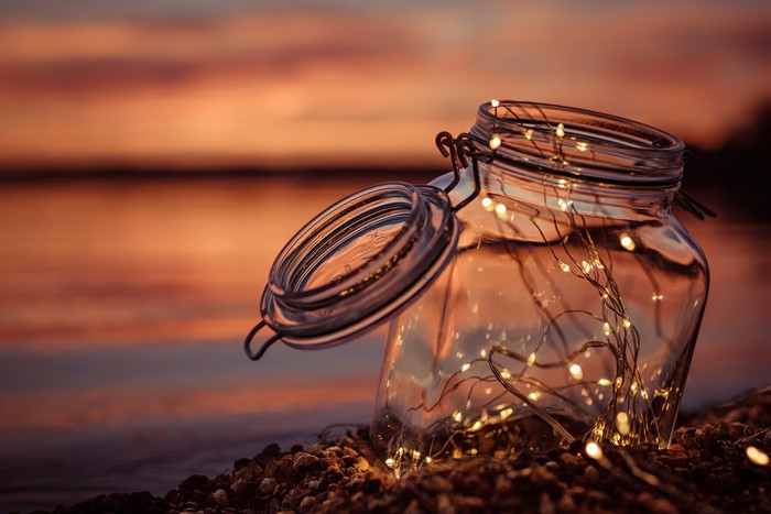 Jar with fairy lights at sunset