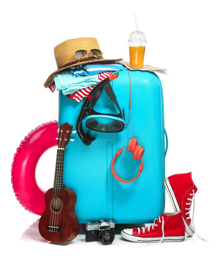 Suitcase packed with travel items including a hat, snorkel, ukulele, camera, and shoes