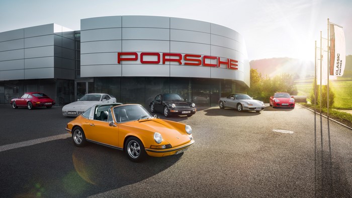Porsche cars parked outside a Porsche dealership