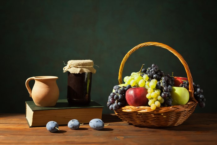 Still life with jam, fruit, jug, and book