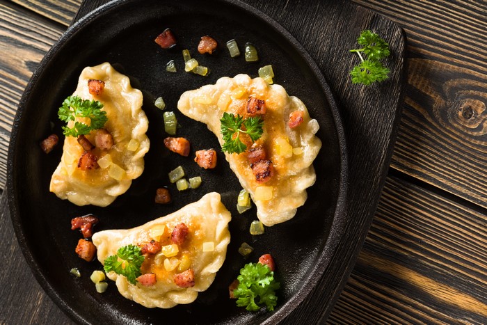 Pierogi with bacon and parsley in a frying pan
