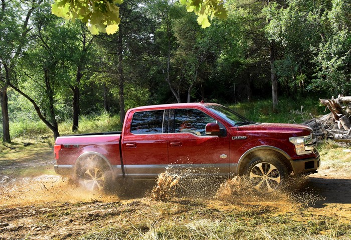 Red 2018 Ford F-150 King Ranch SuperCrew driving through mud