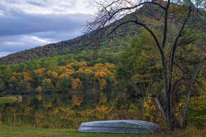 Autumn forest and lake with overturned boat in Virginia, USA