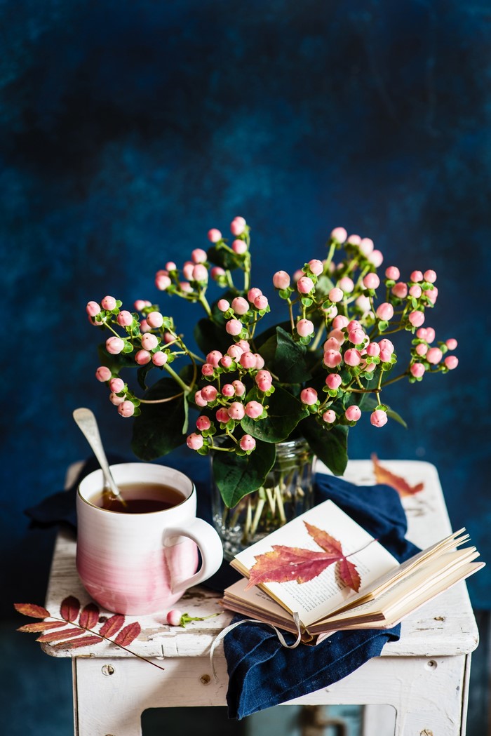 Still life with tea, flowers, and a book