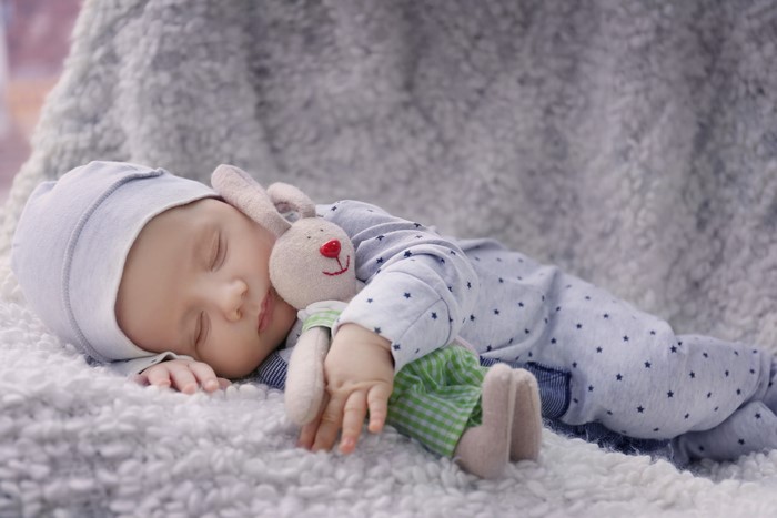 Infant sleeping with a stuffed rabbit toy