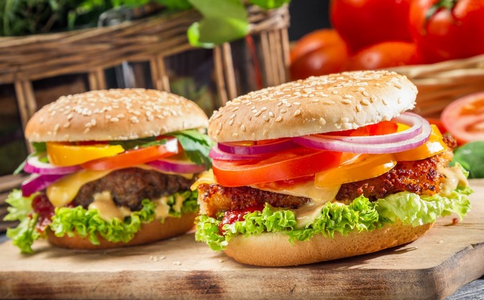 Two gourmet hamburgers with fresh vegetables
