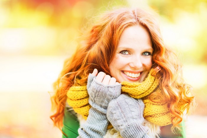 Woman with red hair and yellow scarf in autumn
