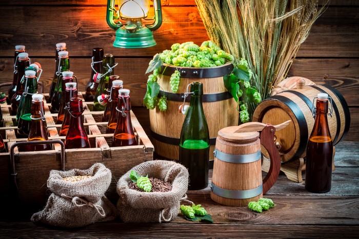 Beer bottles and barrels with hops and wheat