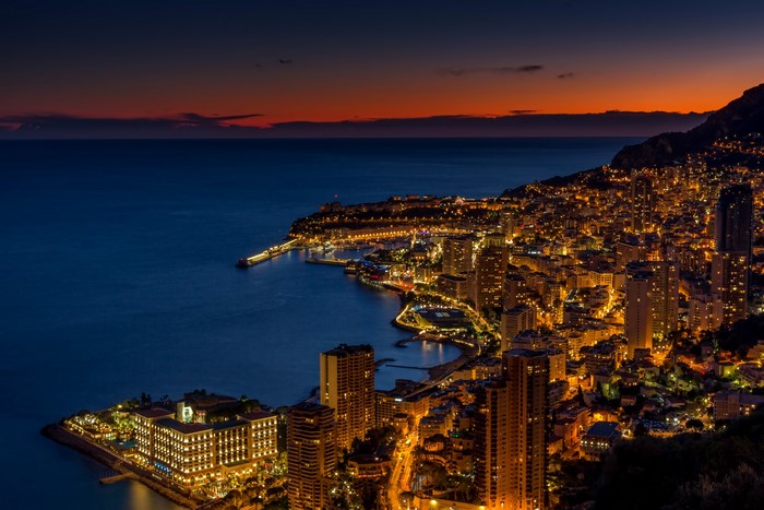 Monaco cityscape at night with illuminated buildings and bay