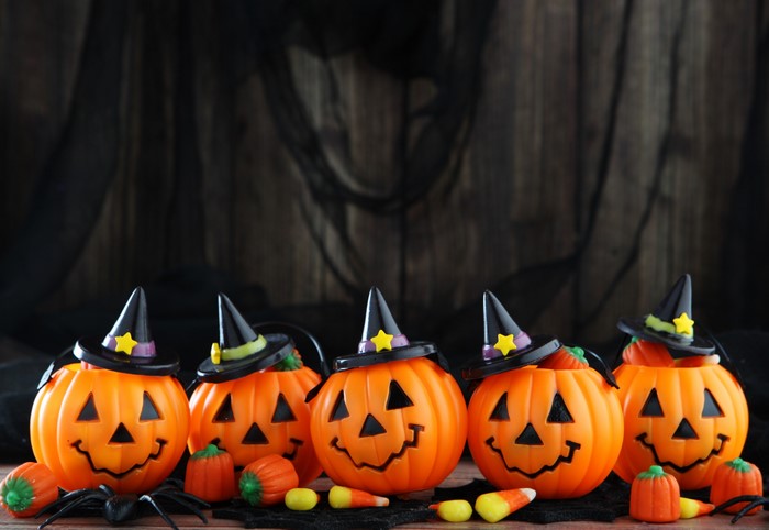 Halloween pumpkin buckets with witch hats and candy