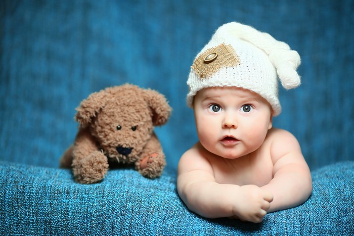 Baby in a hat with a teddy bear
