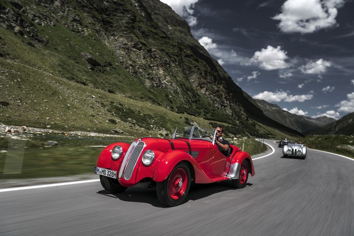 Red BMW 328 Roadster driving on mountain road